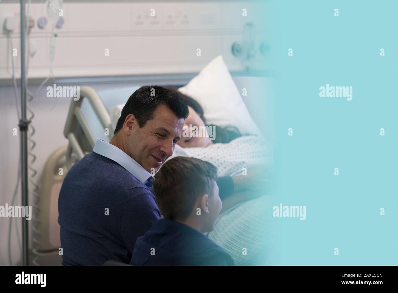 Eine Familie, die einen Patienten im Krankenhauszimmer besucht Stockfoto