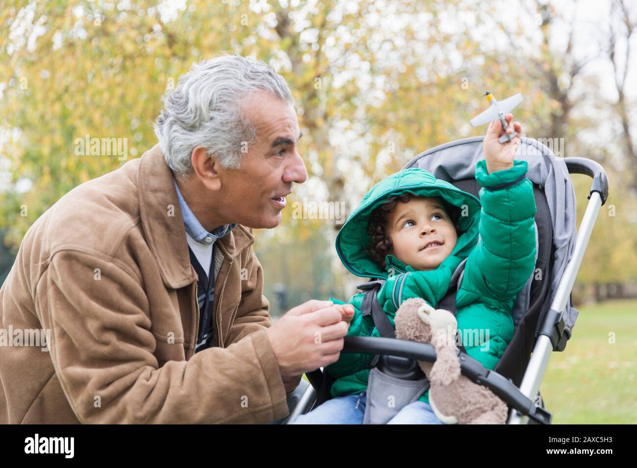 Großvater mit neugierigem Enkel im Kinderwagen Stockfoto