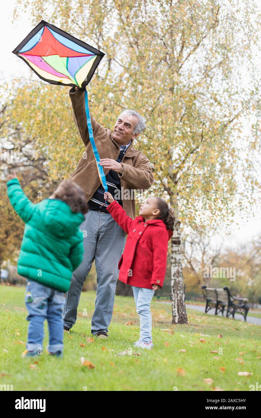 Großvater und Enkel fliegen im Herbstpark einen Drachen Stockfoto