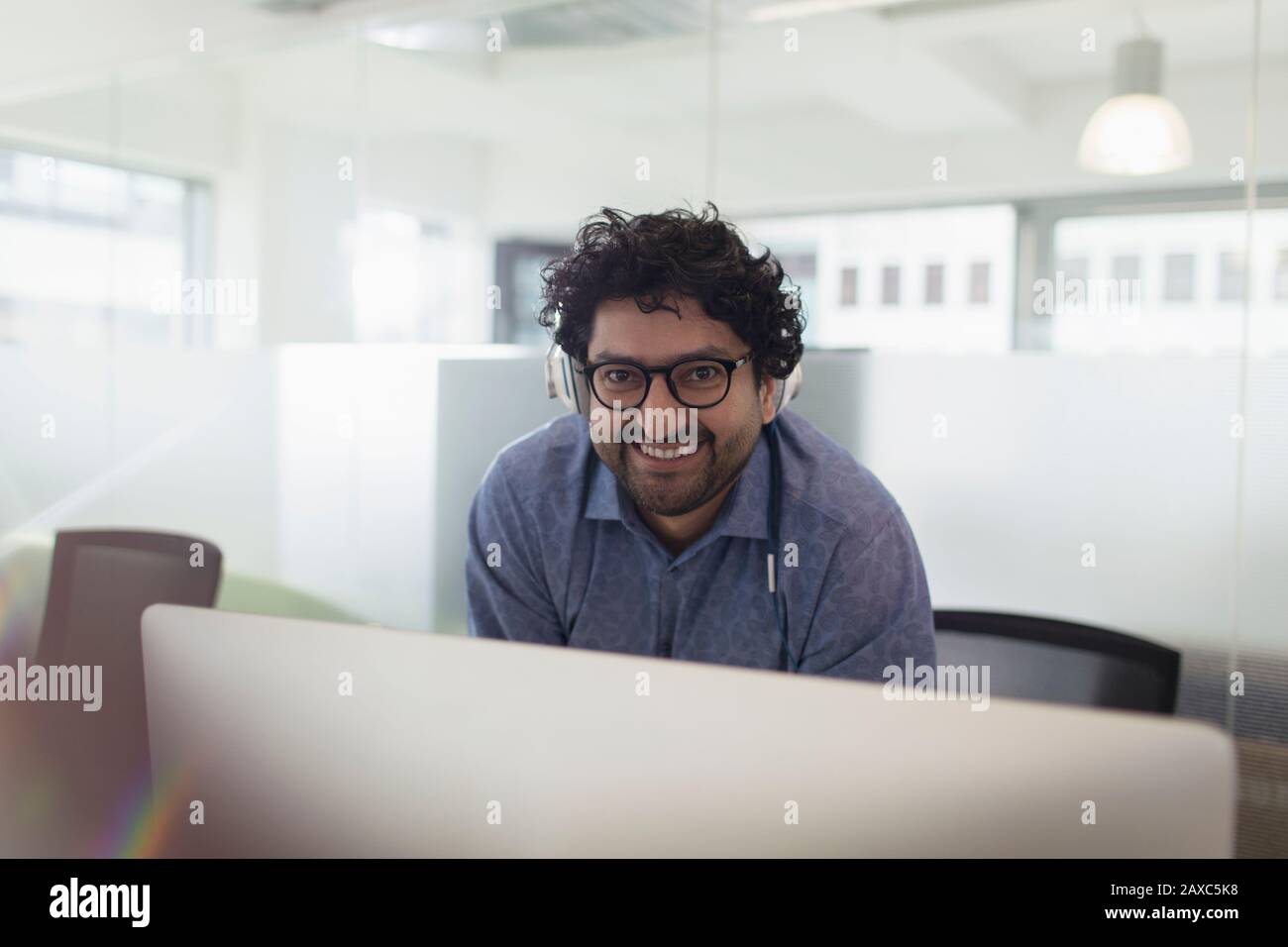 Selbstbewusste Geschäftsleute im Hochformat, die Kopfhörer im Büro tragen Stockfoto