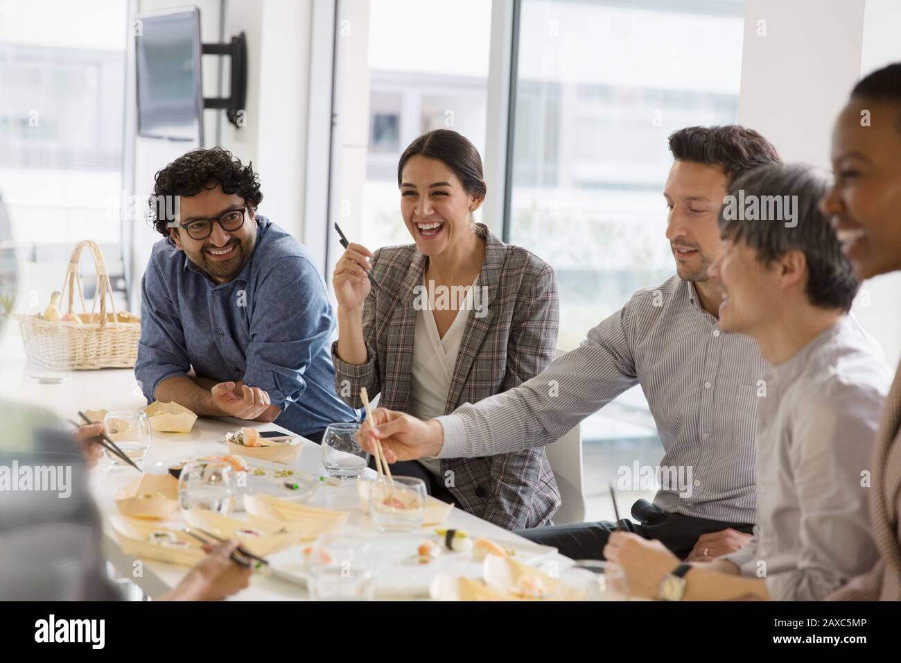 Fröhliche Geschäftsleute genießen Sushi-Mittagessen Stockfoto