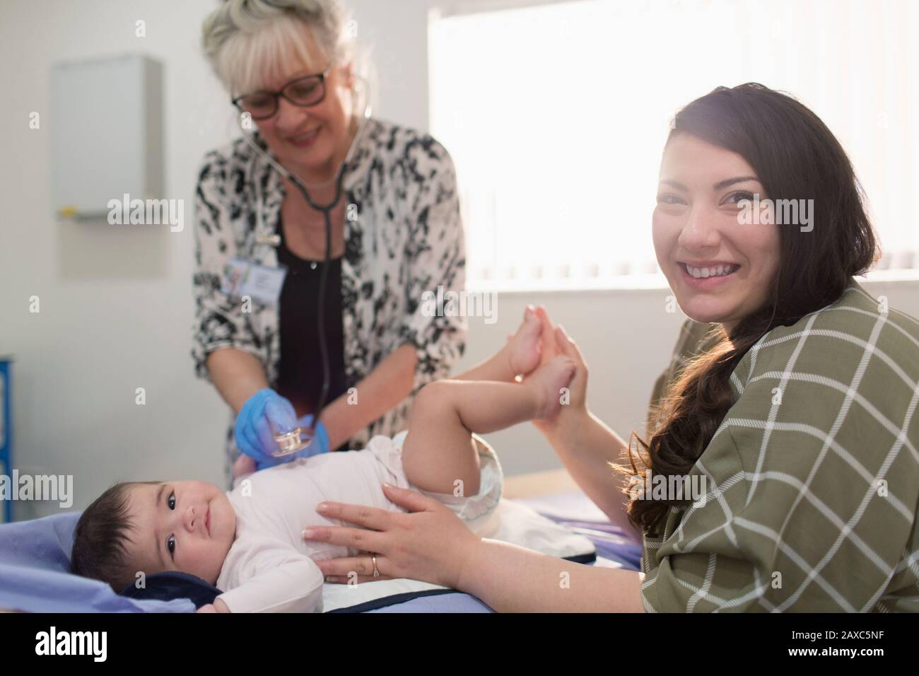 Portrait glückliche Mutter mit Tochter und Kinderärztin im Untersuchungsraum Stockfoto