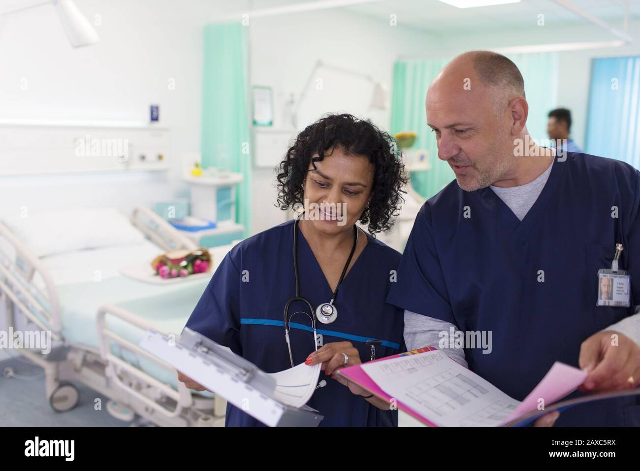 Ärzte mit medizinischen Diagrammen, die Runden kommen, Beratung in der Krankenstation Stockfoto