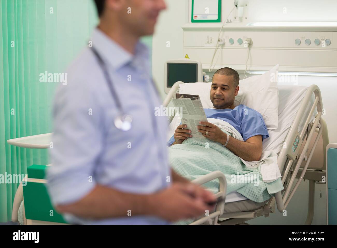 Zeitung mit männlichen Patienten, die im Krankenhauszimmer ruht Stockfoto