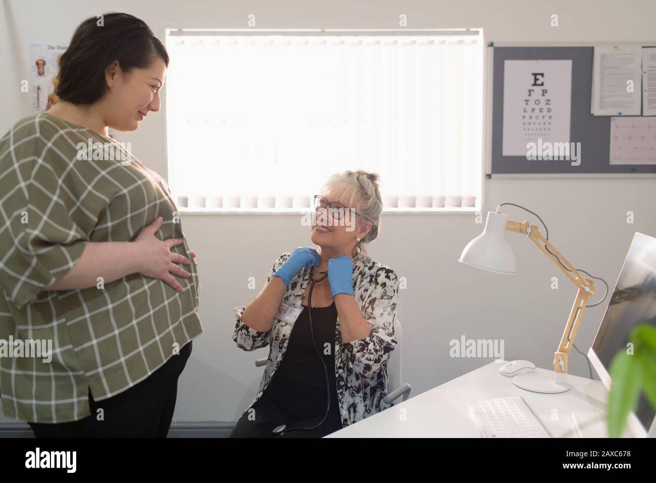 Ärztin untersucht Schwangere im Arztbüro Stockfoto