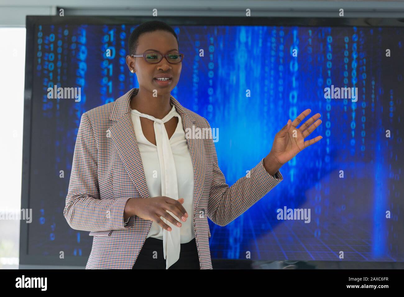 Geschäftsfrau, die das Treffen auf dem Fernsehbildschirm leitet Stockfoto