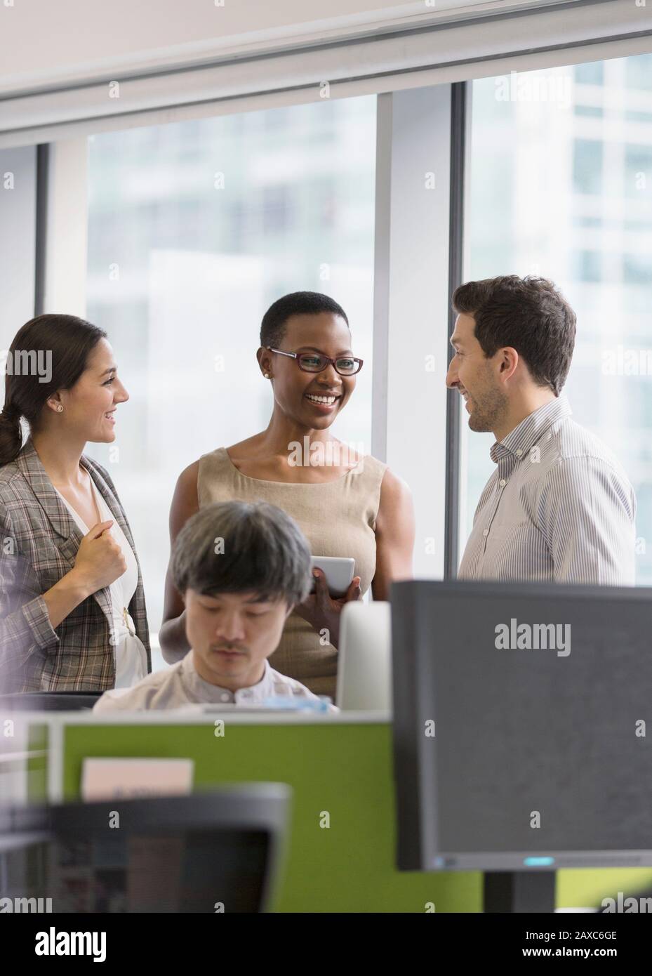 Lächelnde Geschäftsleute sprechen im Büro Stockfoto
