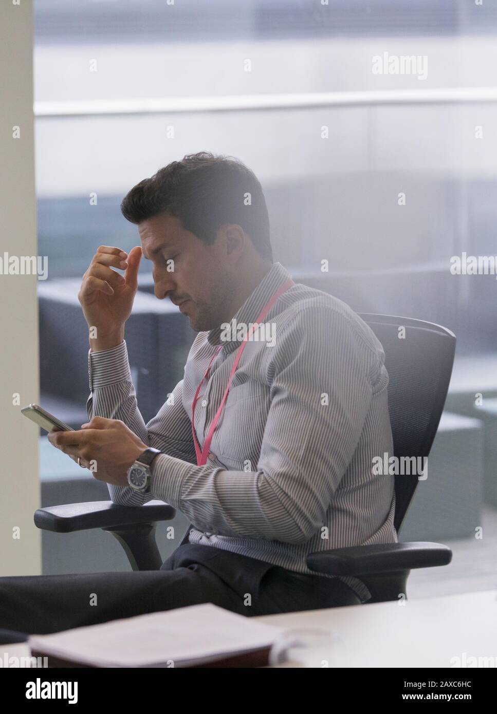 Geschäftsmann mit Smartphone im Büro Stockfoto