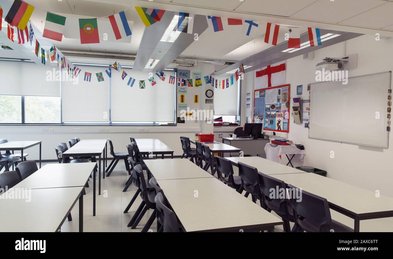 Nationalflaggen hängen über Tischen im Klassenzimmer Stockfoto