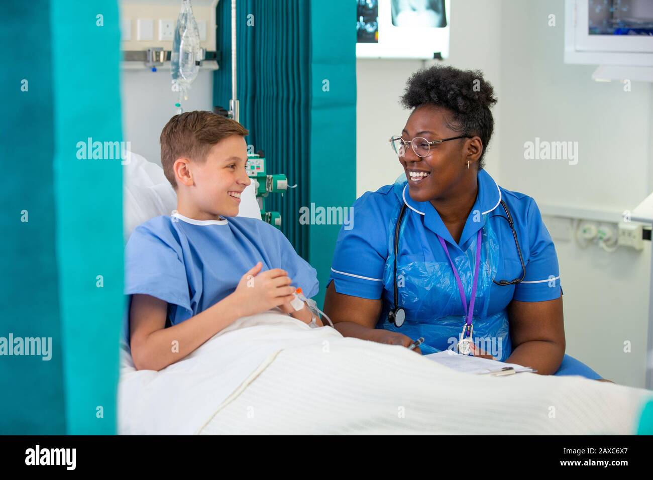 Weibliche Krankenschwester spricht mit einer Patientin im Krankenhauszimmer Stockfoto