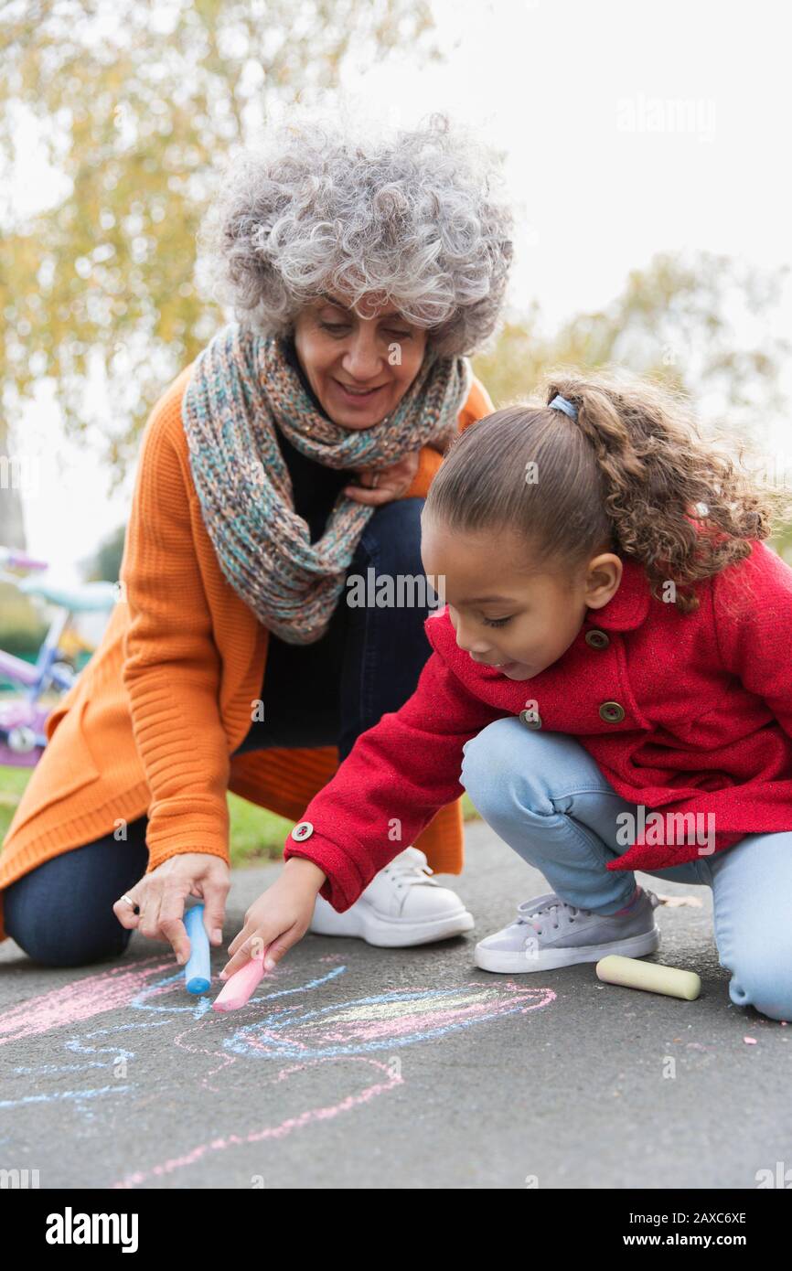 Großmutter und Enkelin zeichnen mit Kreide auf dem Bürgersteig Stockfoto