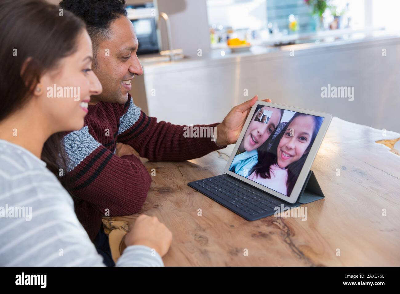 Verbinden Sie Videokonferenzen mit Töchtern auf einem digitalen Tablet in der Küche Stockfoto