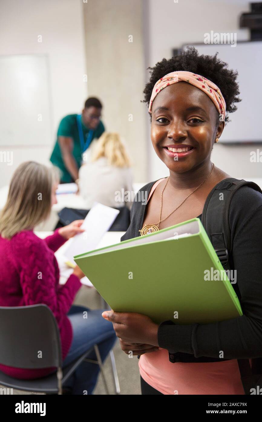 Portrait selbstbewusste Studentin mit Binder im Klassenzimmer Stockfoto