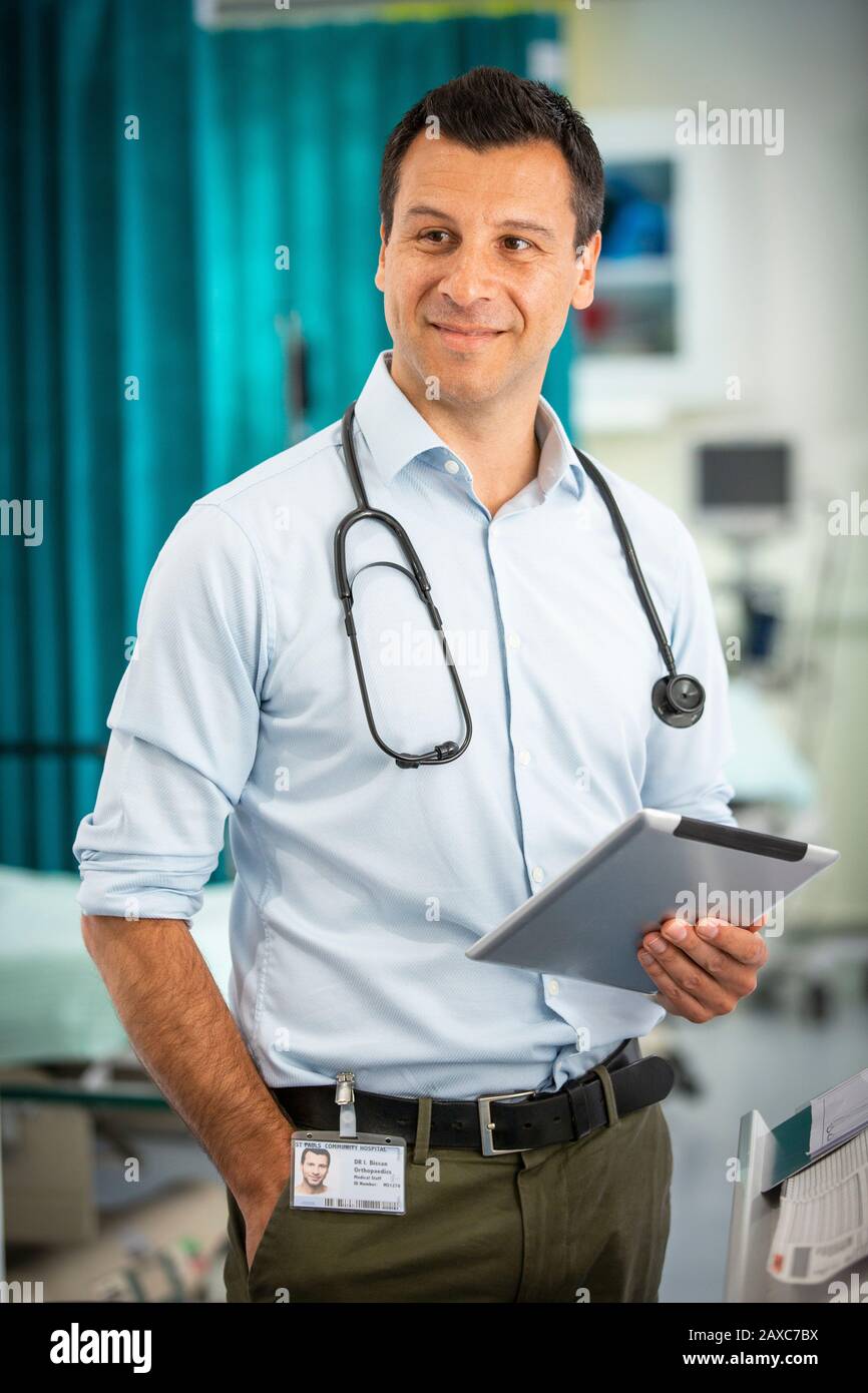 Portrait selbstbewusster männlicher Arzt mit digitaler Tablette im Krankenhaus Stockfoto