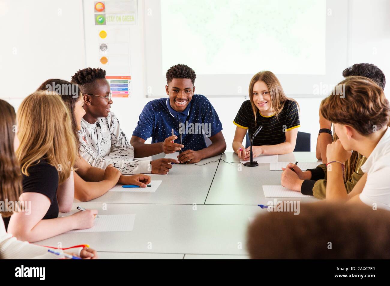 Lächelnde High-School-Schüler sprechen in der Debattierklasse Stockfoto