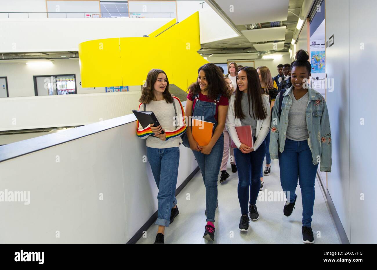 Schüler der jungen hohen Mädchen, die auf dem Flur spazieren Stockfoto