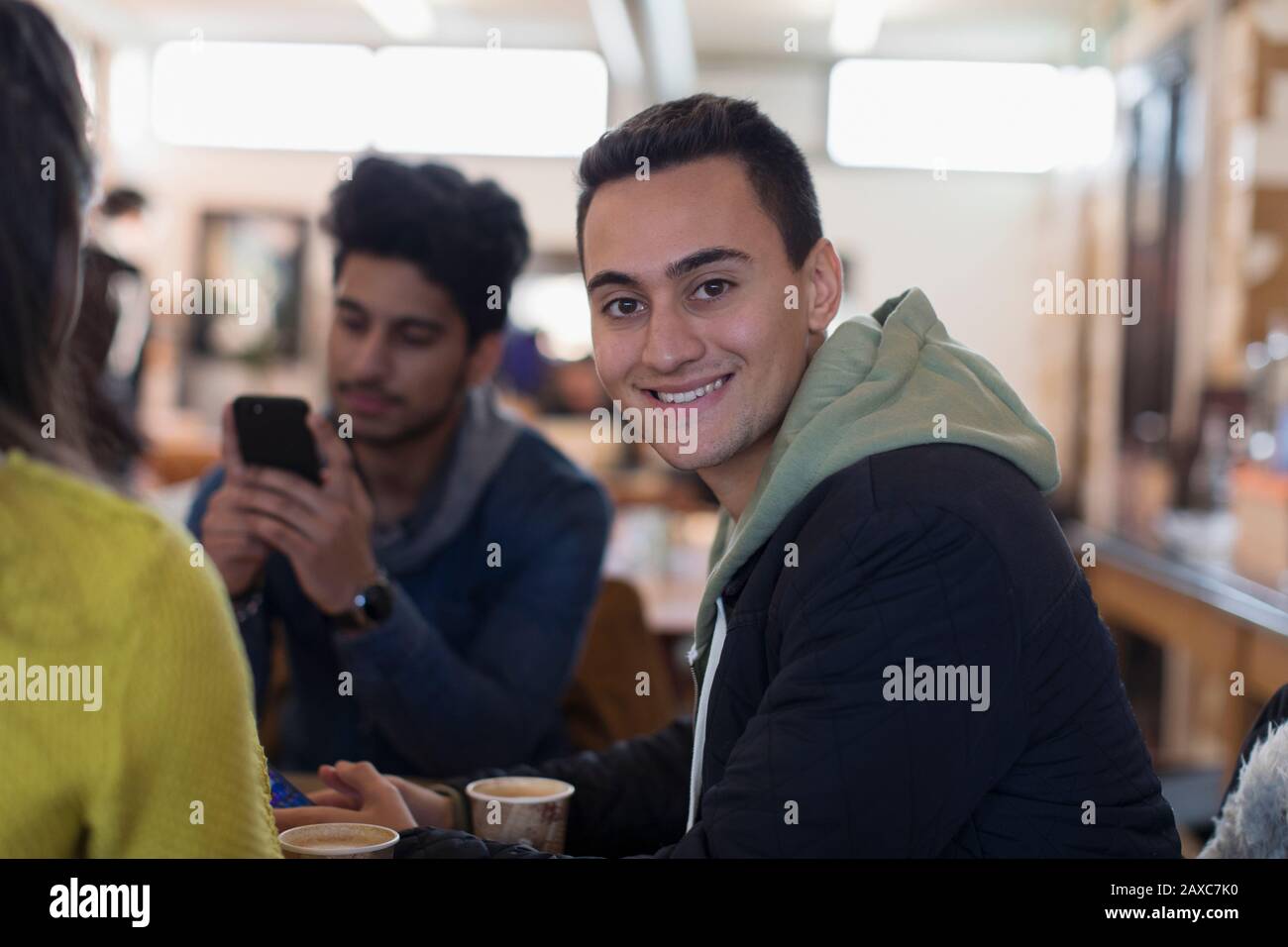 Portrait selbstbewusster junger Mann, der mit Freunden im Café aufhängt Stockfoto