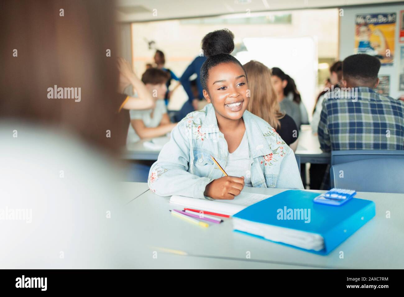 Fröhliche, selbstbewusste Schülerin der High School, die im Klassenzimmer studiert Stockfoto
