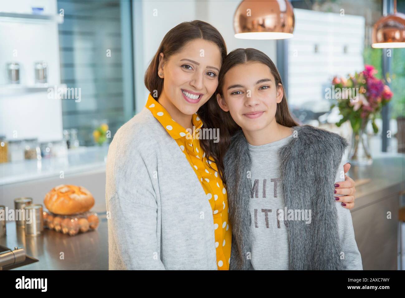 Portrait fröhliche Mutter und Tochter umarmen sich in der Küche Stockfoto