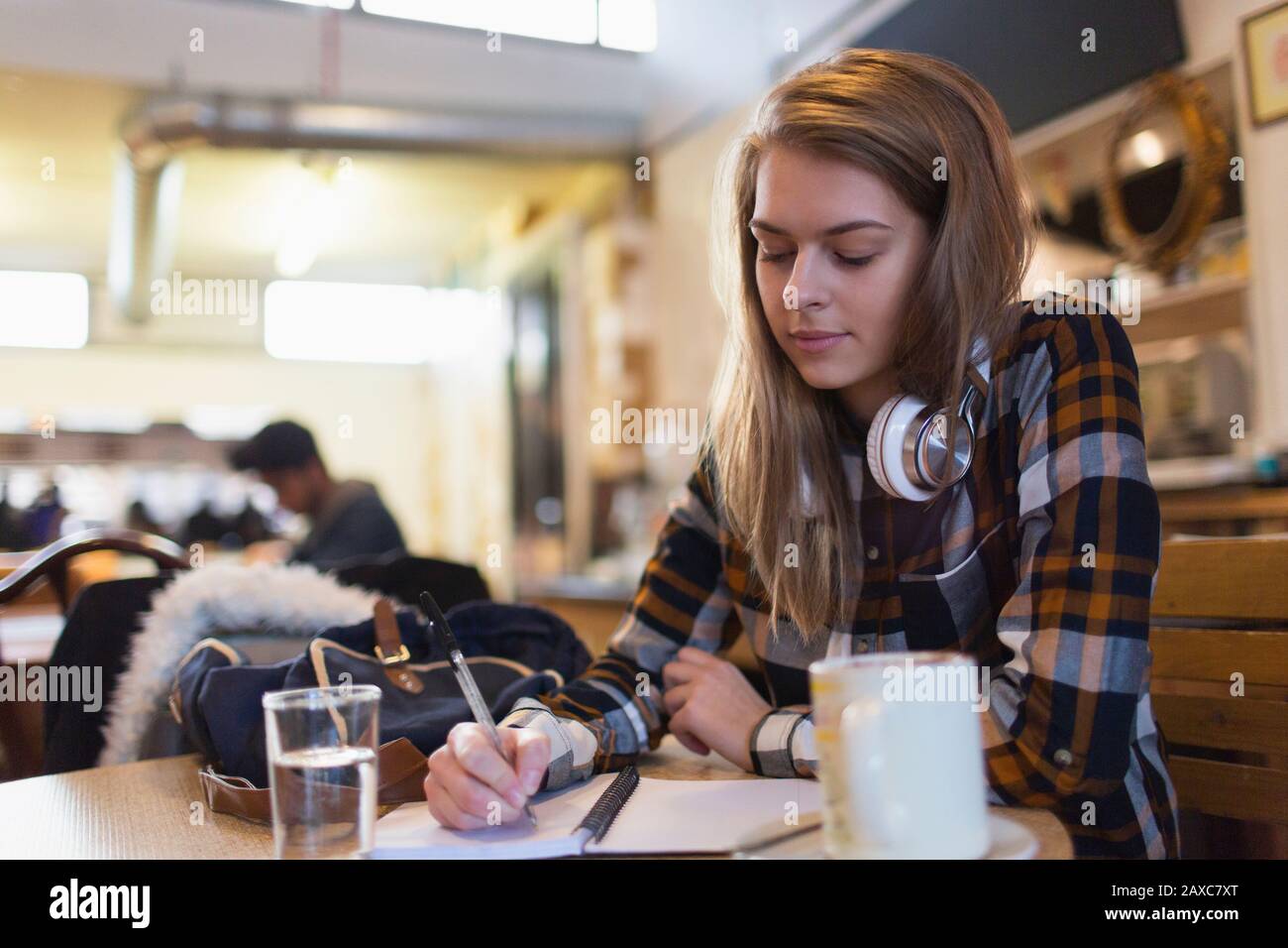Junge Studentin im College, die in Café studiert Stockfoto