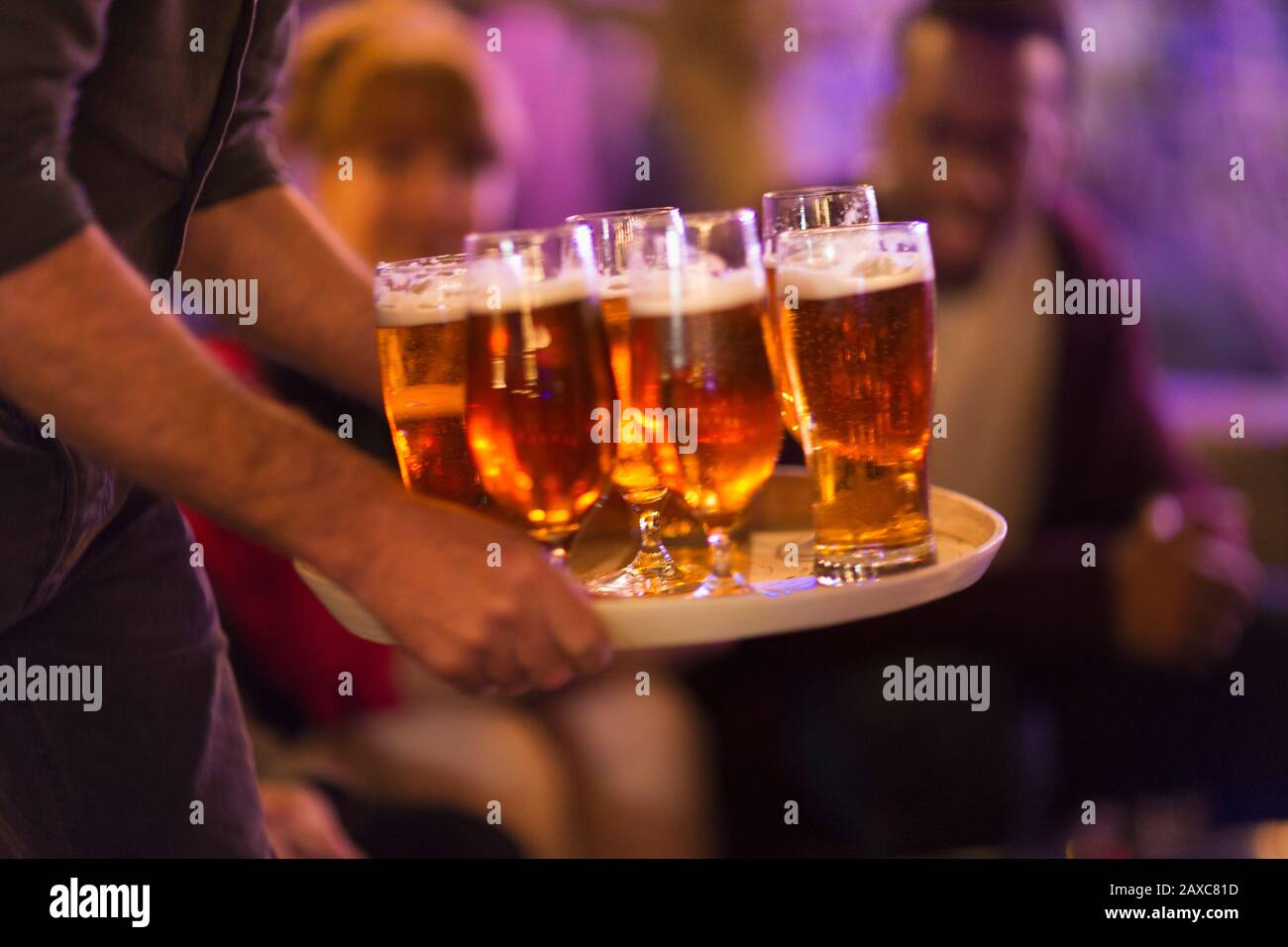Mann, der Freunden ein Tablett Bier serviert Stockfoto