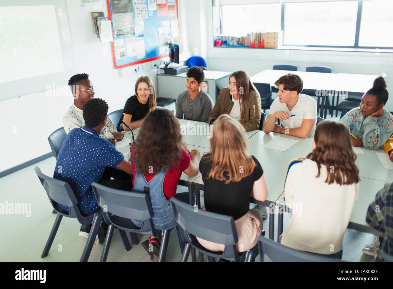 Schüler der High School sprechen in der Debattierklasse am Tisch im Klassenzimmer Stockfoto