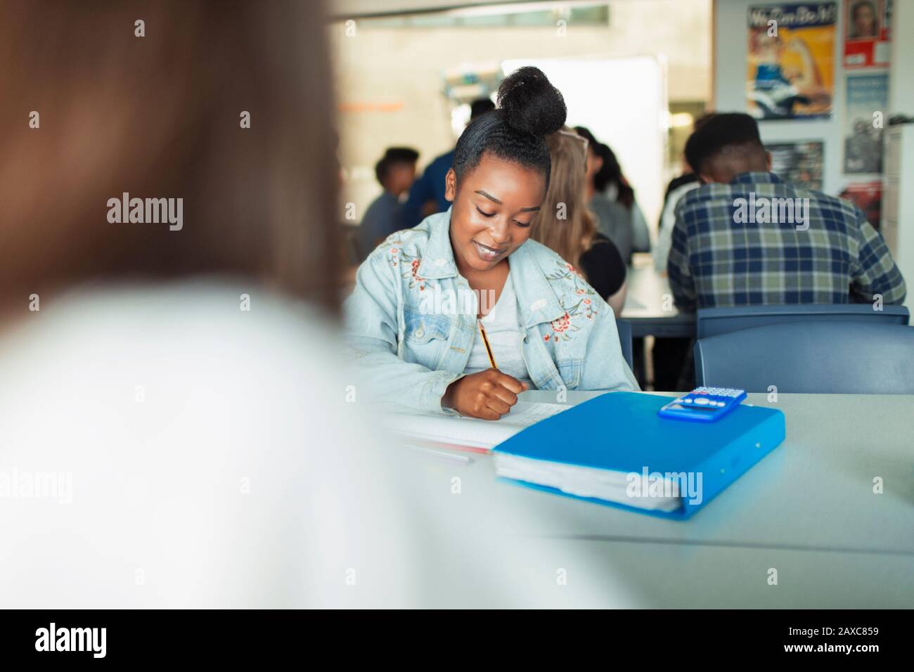 Schüler der High-School-Mädchen, die Hausaufgaben am Tisch im Klassenzimmer machen Stockfoto