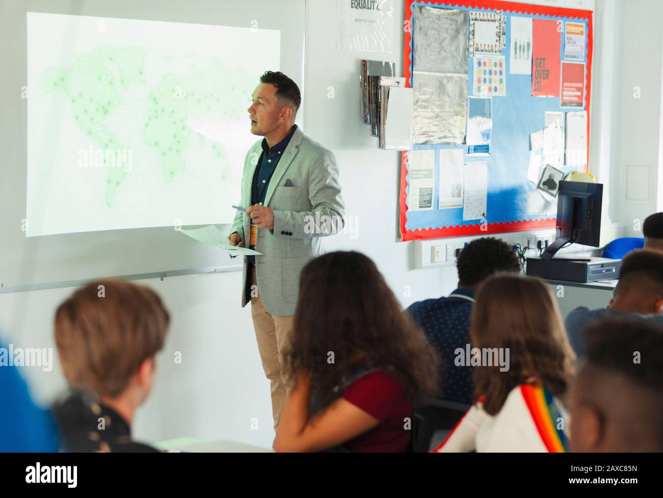 Lehrer der High School, der die Geographie auf der Projektionsleinwand im Klassenzimmer leitet Stockfoto