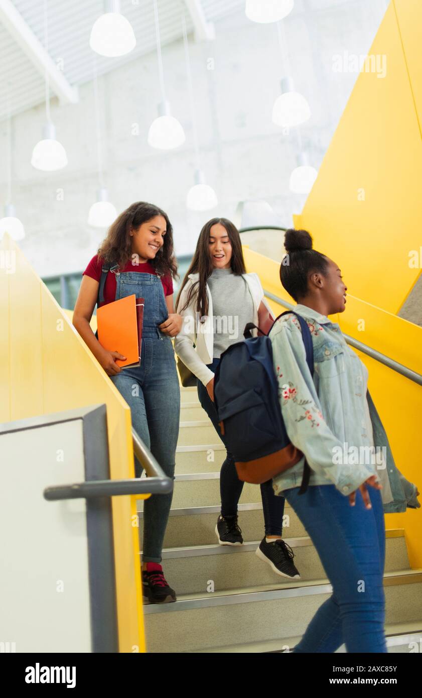 Schüler der jungen hohen Mädchen, die Treppen hinabsteigen Stockfoto