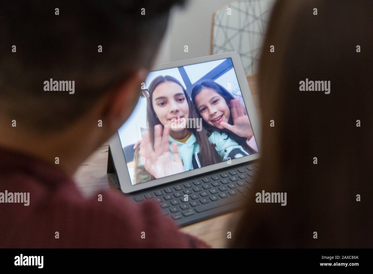 Töchter auf digitalem Tablet winken Eltern, Videokonferenzen mit Eltern Stockfoto