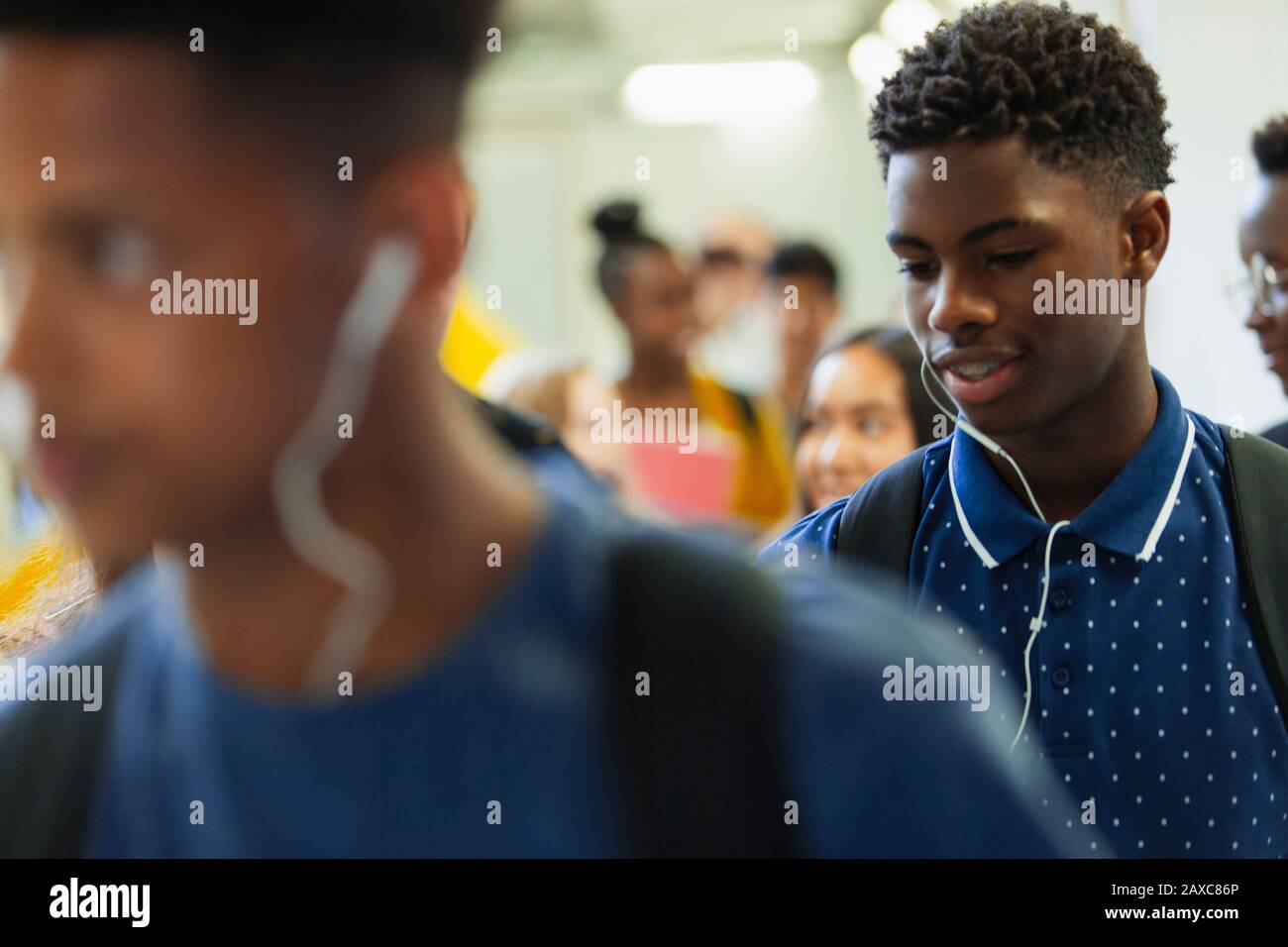 Junior High Boy Student mit Kopfhörern im Korridor Stockfoto