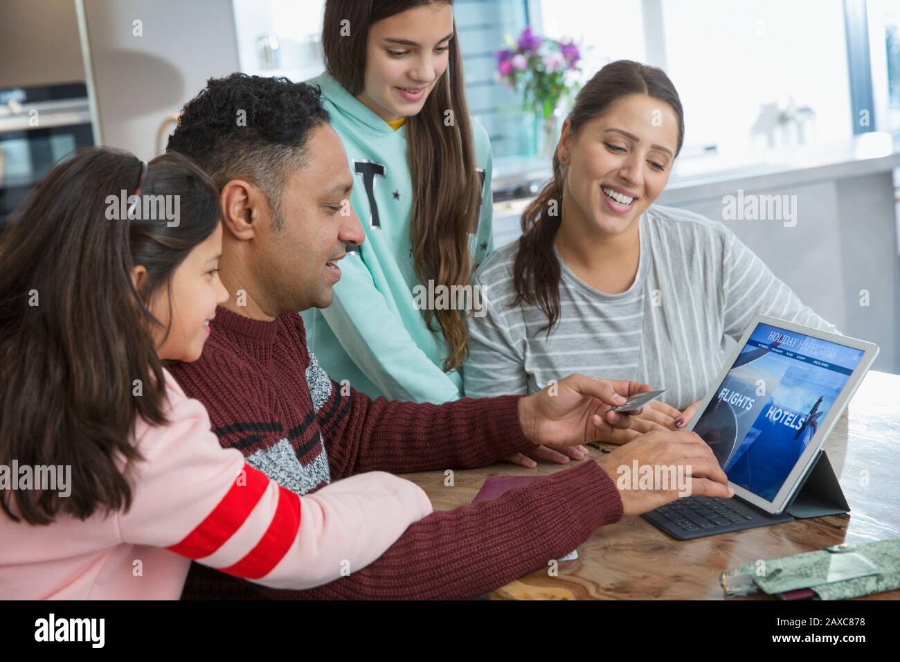 Glückliche Familienplanung und Bezahlung für den Urlaub auf dem digitalen Tablet Stockfoto