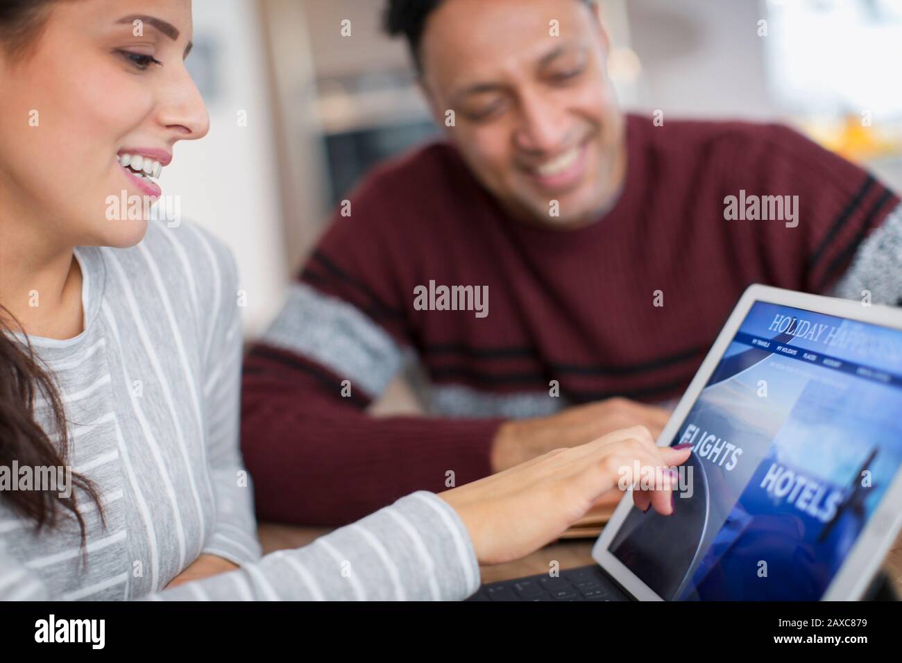 Glückliches Paar plant Urlaub auf dem digitalen Tablet Stockfoto