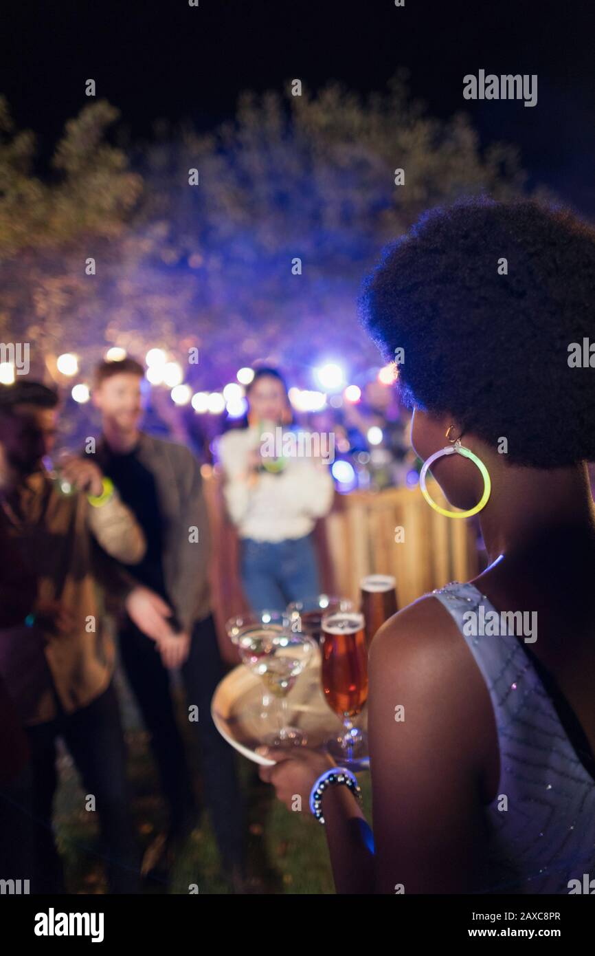 Junge Frau, die Cocktails auf der Gartenparty serviert Stockfoto