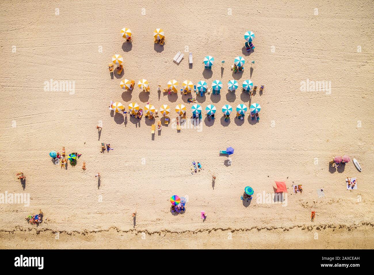 Top-down-Luftansicht des Strandes mit bunten Sonnenschirmen und Badegästen in South Beach Miami, Florida, USA. Stockfoto