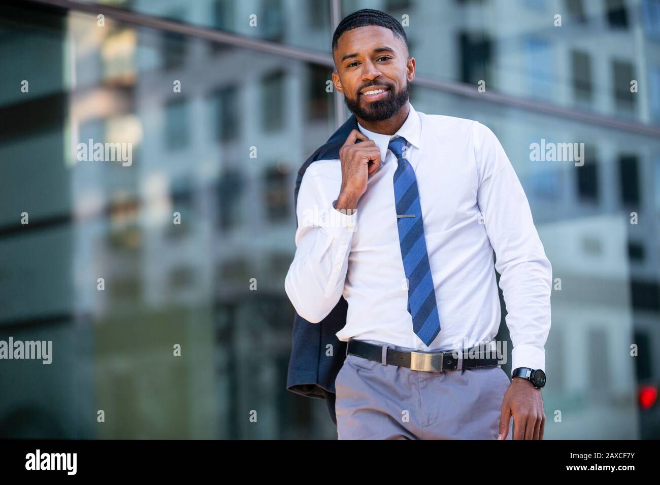 Modernes, modisches porträt eines afroamerikanischen Geschäftsmannes in der Stadt, der zu Fuß im Finanzviertel arbeitet Stockfoto