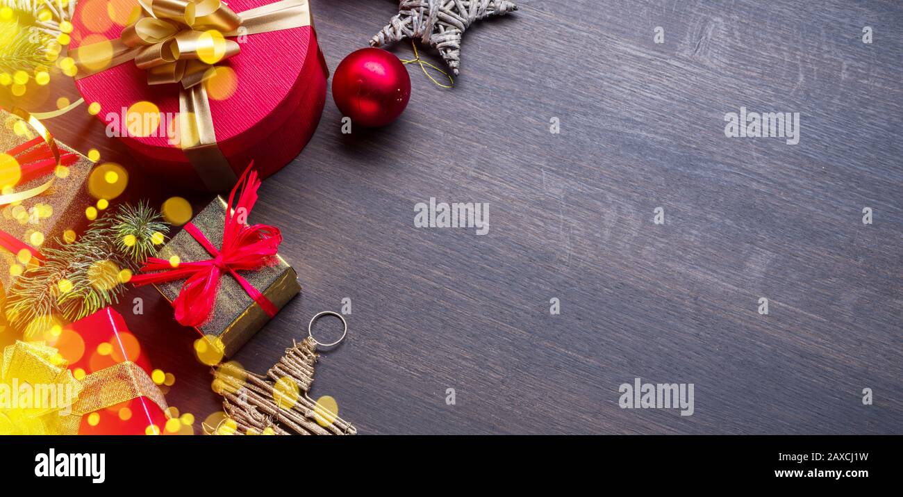 Weihnachtsdekoration, Geschenkschachteln und verschwommene Lichter auf dunklem Holztisch. Weihnachten oder Silvester Hintergrund zeigt den Zauber der Weihnachtsferien Stockfoto