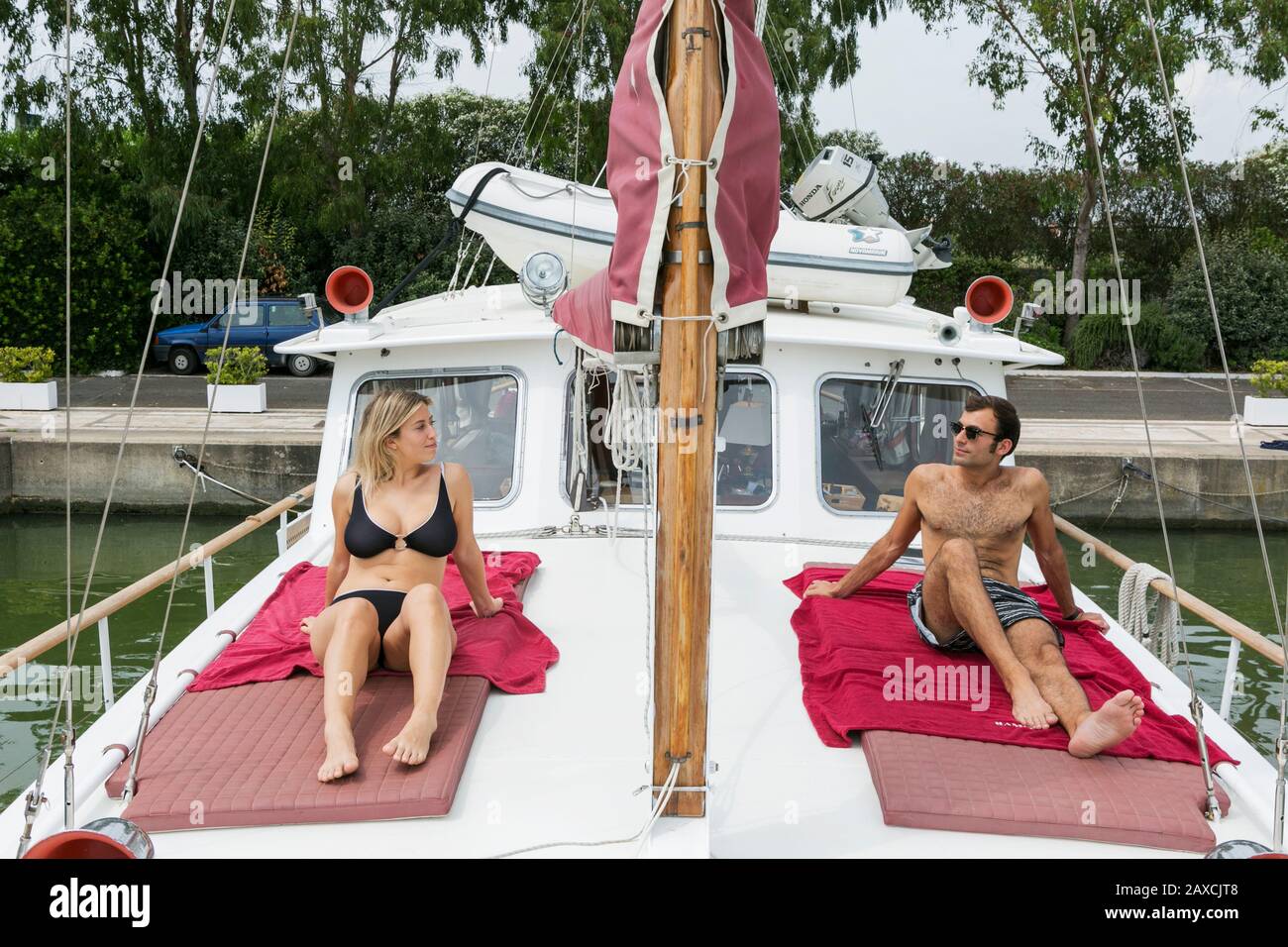 Junges Paar in Schwimmkostümlounge auf einem Boot Stockfoto