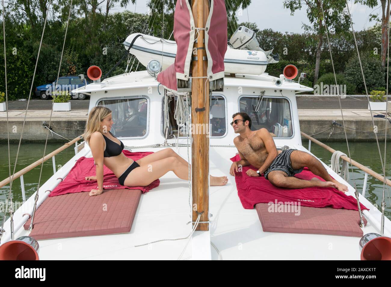 Junges Paar in Schwimmkostümlounge auf einem Boot Stockfoto
