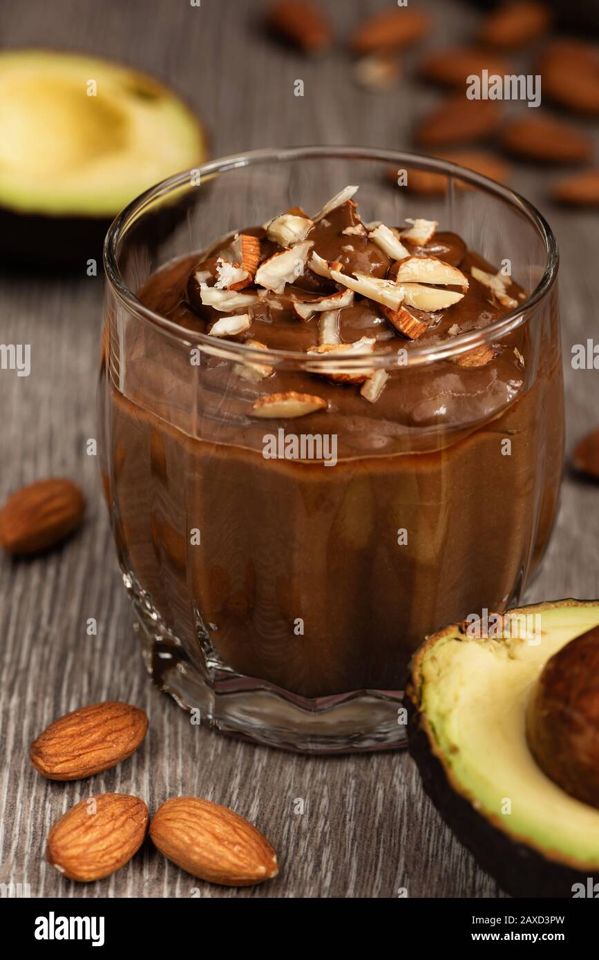 Сhocolate Dessert mit Avocado in einem Glas auf einer Holzoberfläche. Vegane Rohprodukte. Stockfoto
