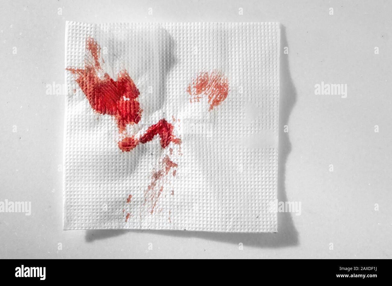 Küchenpapier Serviette im Blut. Blut mit improvisierten Mitteln stoppen. Stockfoto