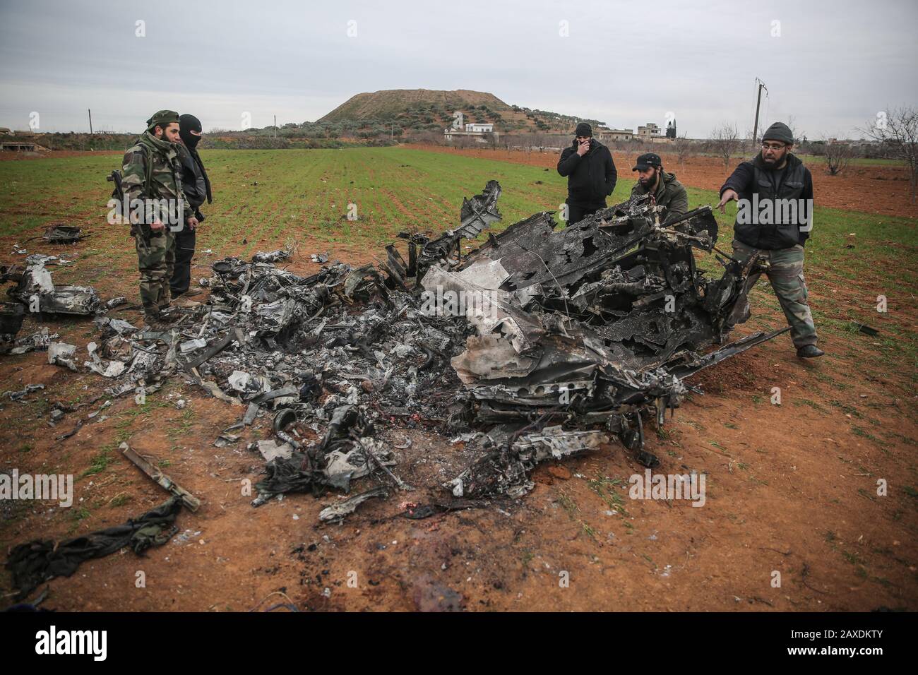 Qmenas, Syrien. Februar 2020. Syrische Rebellen untersuchen die Trümmer eines Militärhubschraubers, der syrischen Regierungstruppen gehört, nachdem dieser in der von Rebellen gehaltenen Provinz Idlib abgeschossen wurde. Credit: Anas Alkharboutli / dpa / Alamy Live News Stockfoto