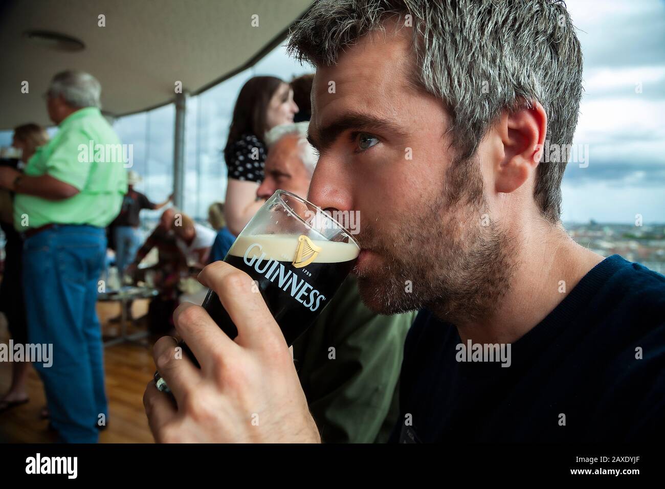Mann trinkt Guinness Stockfoto