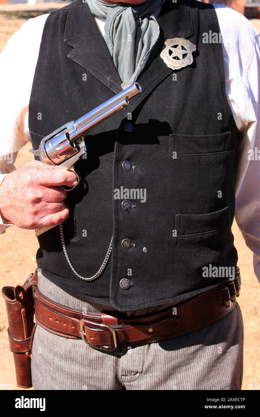Nahaufnahme eines US-amerikanischen Marschall-Stars und des Colt Peacemaker Revolvers, der stolz vom Reenactor bei einer Veranstaltung in Tucson AZ gezeigt wurde Stockfoto