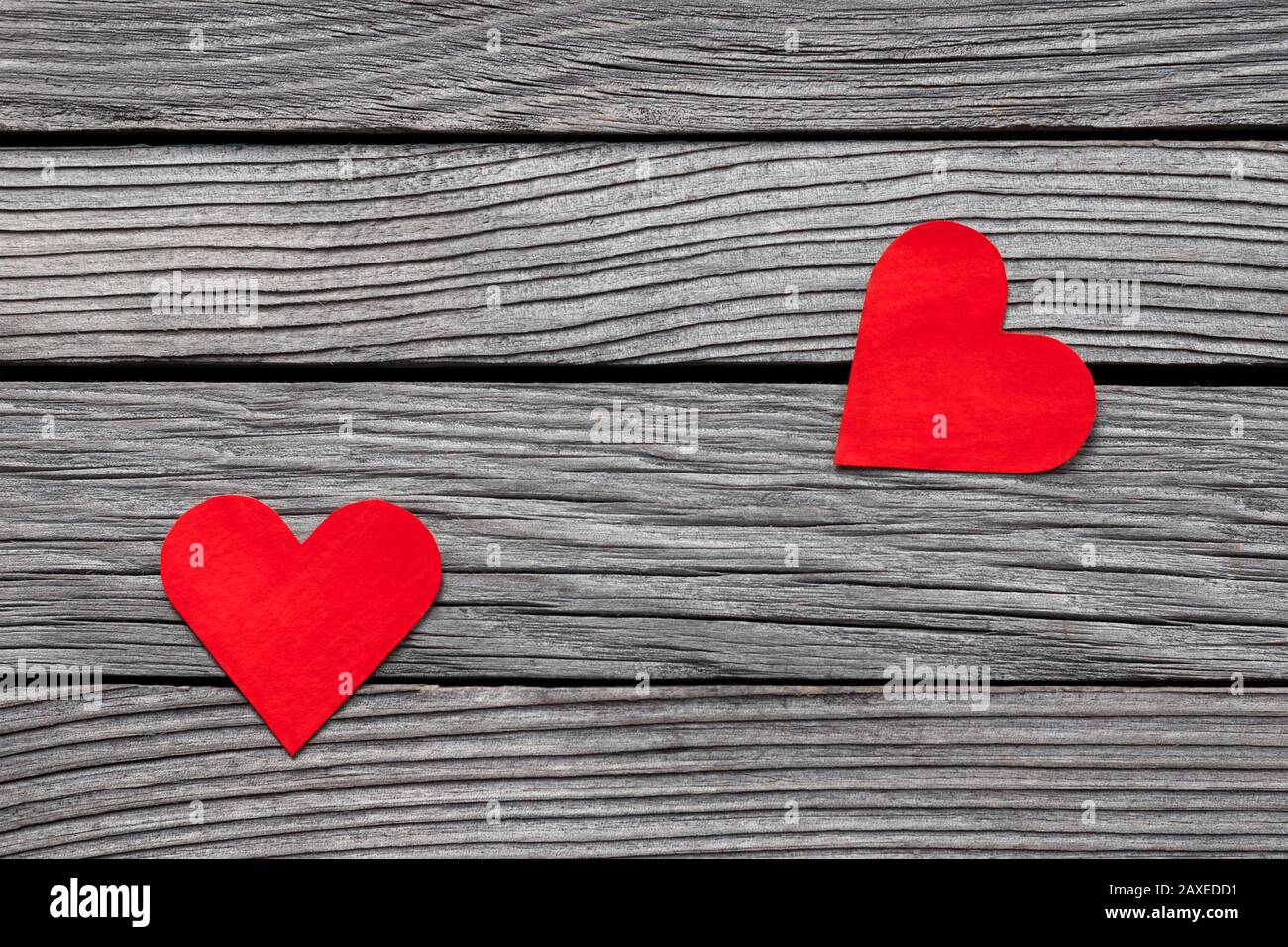 Paar rote Papierherzen auf grauem Holz, einfache Liebesgeschichte, brechen auf Stockfoto