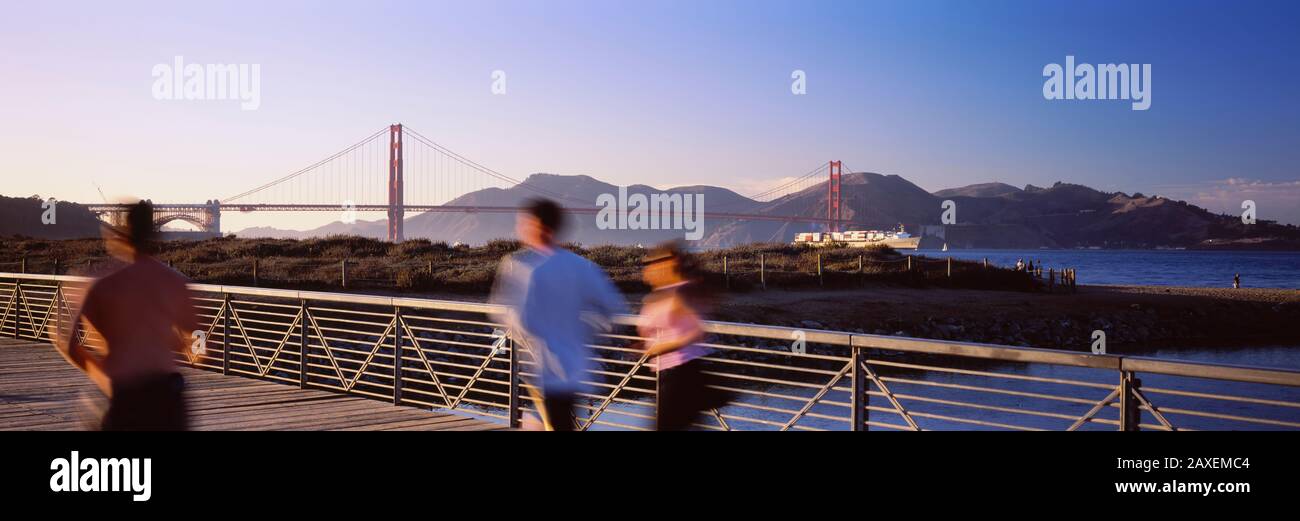 Rückansicht Von Drei Personen Joggen Auf EINER Brücke, Golden Gate Bridge, San Francisco, Kalifornien, USA Stockfoto