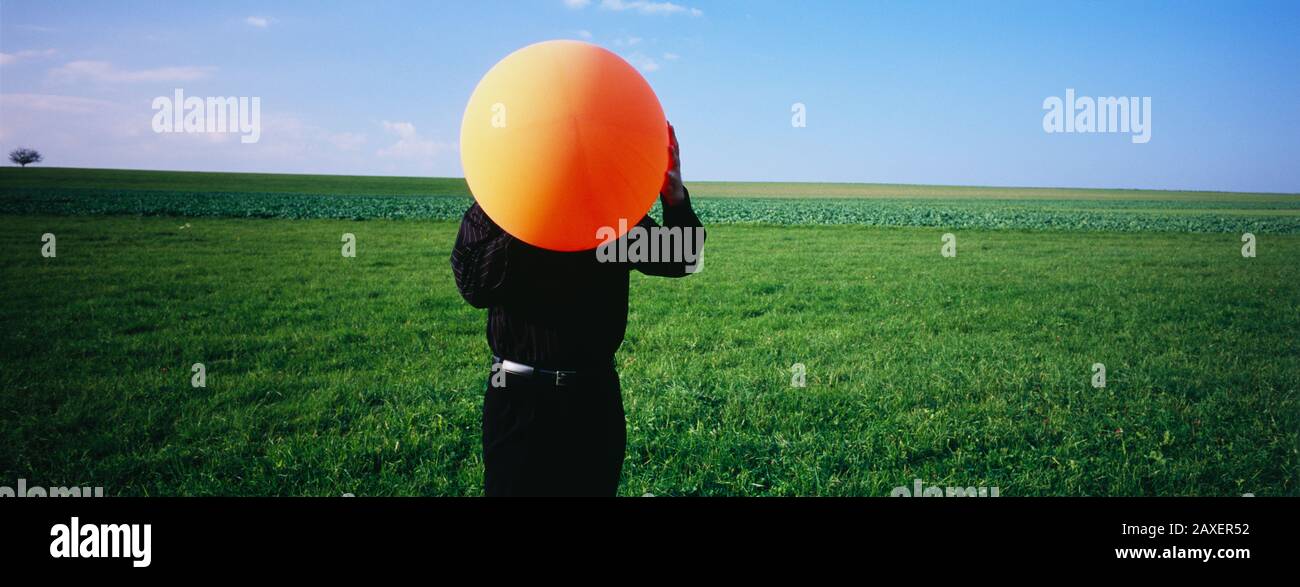 Mann bläst einen Ballon, Deutschland Stockfoto