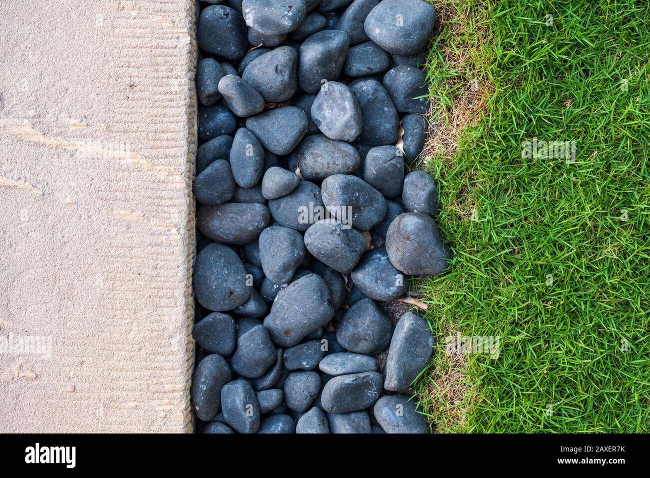 Ein dreifarbiges Foto aus weißem Zement, blauen Steinen und grünem Gras mit Platz für Text Stockfoto