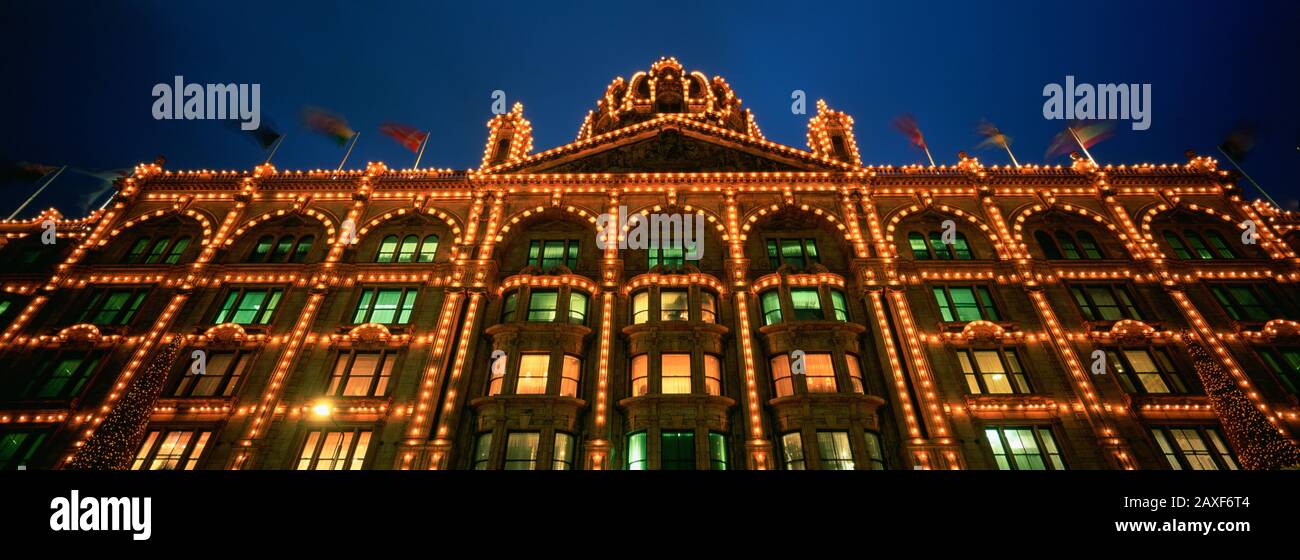 Blick in den niedrigen Winkel eines nachts beleuchteten Gebäudes, Harrods, London, England Stockfoto