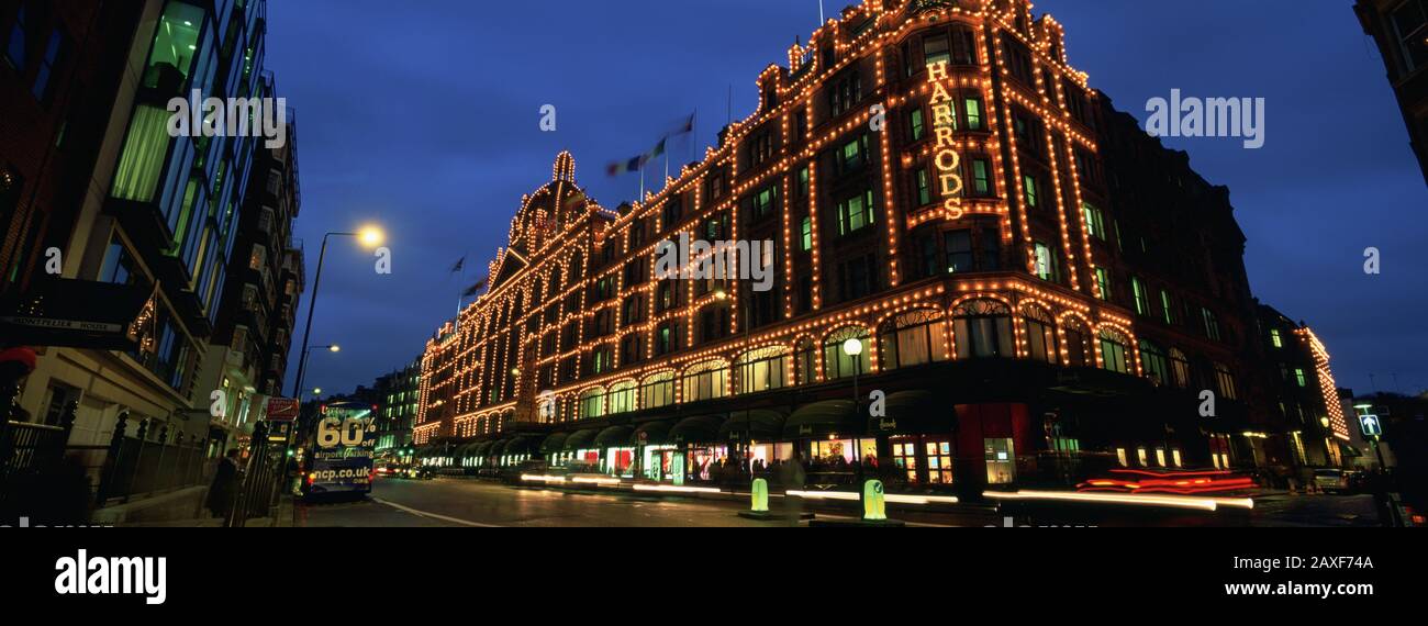 Blick auf die nachts beleuchteten Gebäude, Harrods, London, England Stockfoto